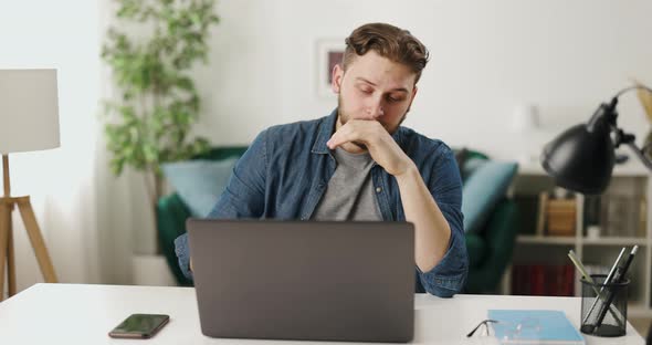 Thoughtful Man Looking on Laptop
