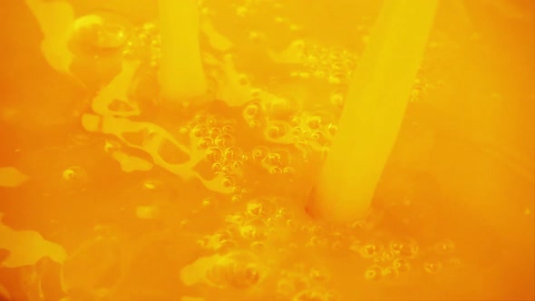 Pouring and splashing orange juice. Slow motion. alt