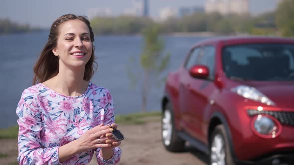 The Girl is Standing Near the Car the Keys Fly Into the Frame She Catches Them and Smiles alt