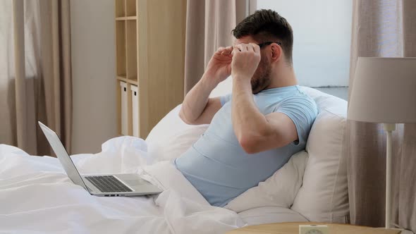 Man in Glasses with Laptop Getting Out From Bed