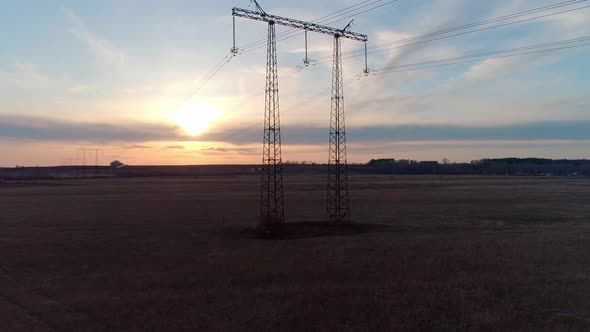 Aerial Video of the Electric Pole with Wires Against Sky at Sunset alt