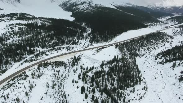 White Car Drives Along The Road In The Black Forest Through Snowy Rocky Mountains In Alberta Canada By Dk Films