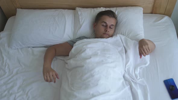 Man Waking Up From Sleep on Bed