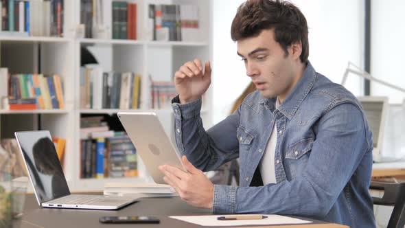 Creative Man Reacting To Online Loss on Tablet alt