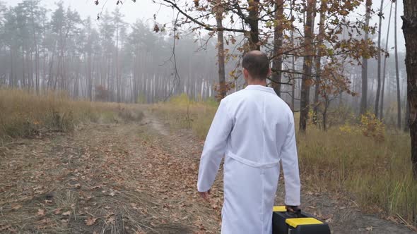 In the Forest, an Ecologist Walks with a Tool Box. Environmental Pollution Studies