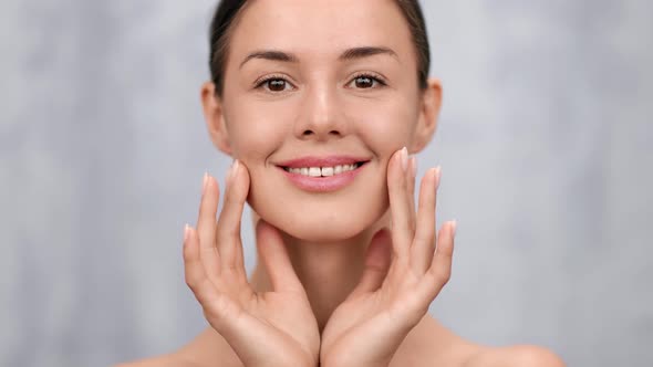 Closeup Smiling Female Applying Moisturizing Cream on Fresh Healthy Face Skin alt
