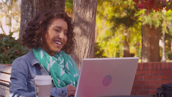 College student on campus in fall using laptop computer