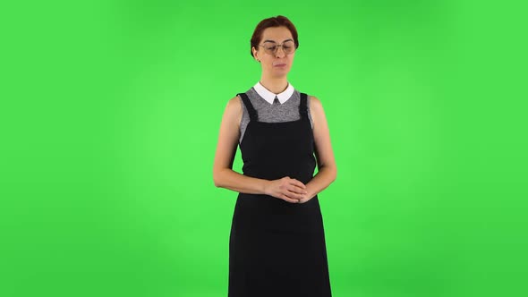Funny Girl in Round Glasses Is Shyly Saying Wow and Smiling. Green Screen alt