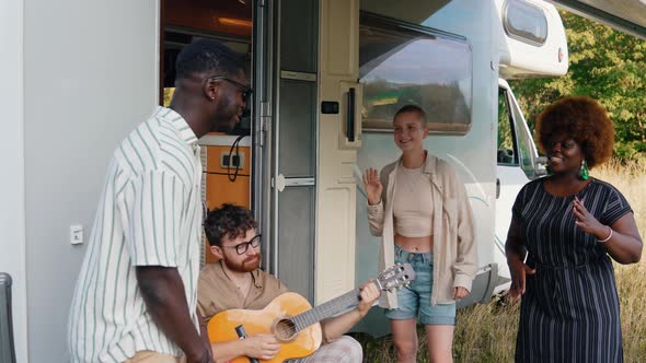 A Multicultural Group of Good Old Friends Singing and Dancing Near Their Camper Van alt