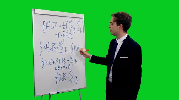 Young Intelligent Man In Suit Explaining Formulas On Whiteboard