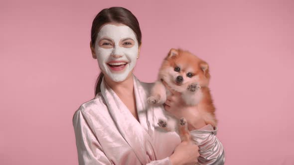 30s Brunette Woman with Her Pet Dog Makes a Facial Mask Routine