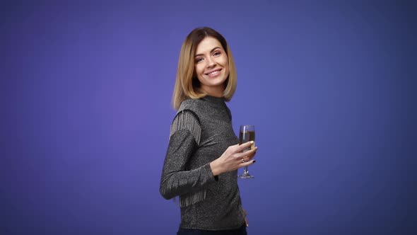 Woman in Silver Shirt Holding Glass of Champagne and Smiling