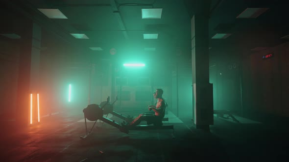 A Man and a Woman in a Colored Neon Red and Blue Light Do a Workout on a Rowing Simulator Together alt