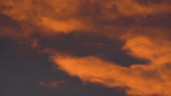 Yellow-Orange Clouds Glowing at Sunset Floating Across Dramatic Purple Sky