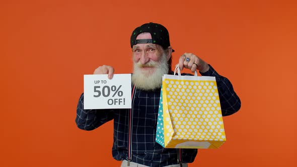 Senior Bearded Man Showing Shopping Bags and Up To 50 Percent Off Inscriptions Banner Black Friday alt