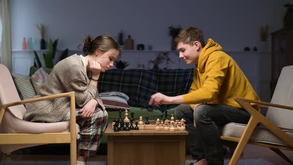 A young man wins a game of chess from his girlfriend by checkmating her alt