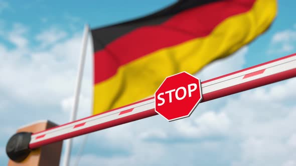 Opening Boom Barrier with Stop Sign Against the German Flag alt