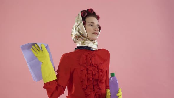 A Woman in a Red Blouse and Hair Curlers is Tired of Cleaning the House