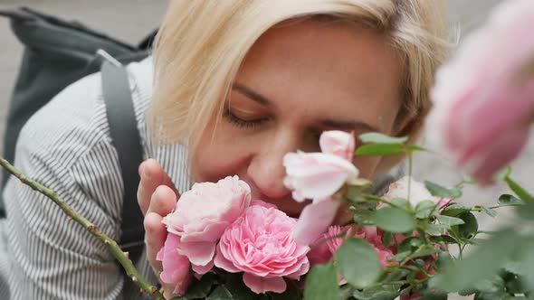 a Cute Adult Caucasian Blonde with a Beautiful Smile Sat Down and Smelled the Aroma of a Rose