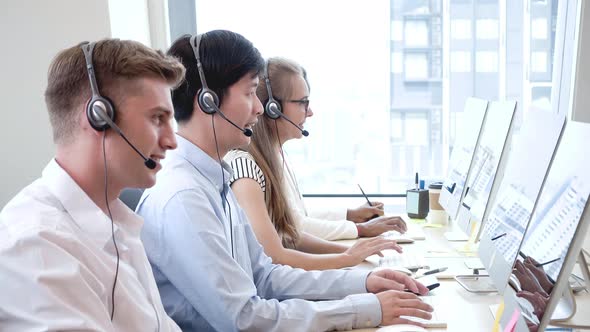 Customer care and support team wearing headphones working in call center office