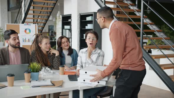 Arab Man Bringing Pizza To Colleagues Multiethnic Group Sitting at Table in Shared Office alt