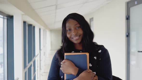 Young African Woman Student with a Books in a Modern Library alt