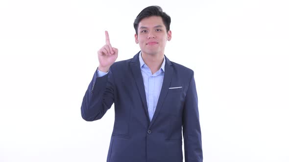 Happy Young Asian Businessman Pointing Up alt