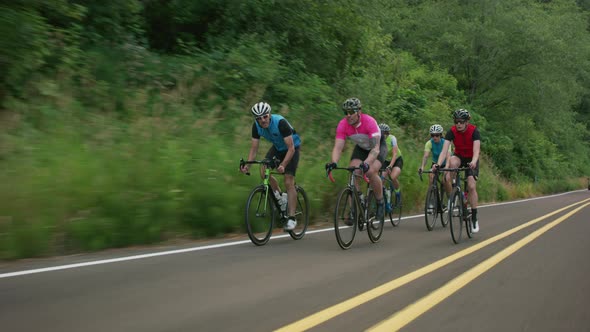 Tracking shot of a group of cyclists on country road.  Fully released for commercial use.