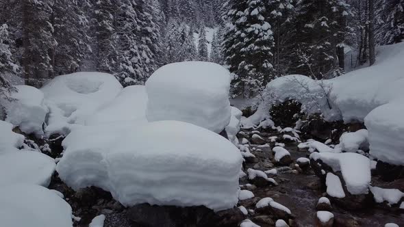 winter wonderland in the alps. A small valley with a snowy creek, Kleinwalsertal, Austria. Drone fly alt