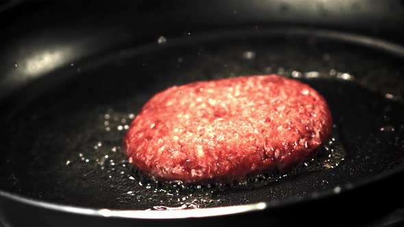 Super Slow Motion with a Splash of Oil Fried Burger in a Frying Pan alt
