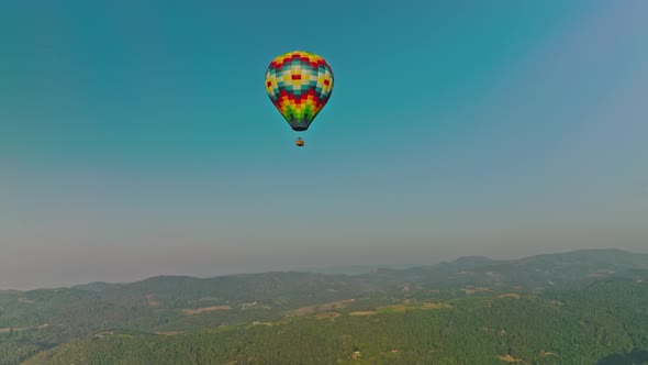 Hot air balloon rising over small town in the Napa Valley alt
