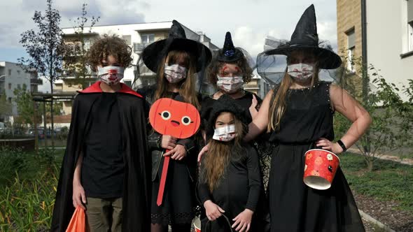 Group Portrait of Children in Black Fancy Dress. Everyone Has Medical Masks on Their Faces alt