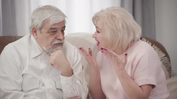 Emotional Mature Caucasian Woman Scolding Elderly Husband at Home, Displeased Couple of alt
