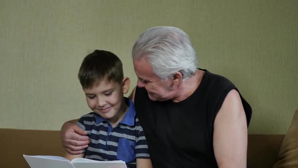 Grandfather Hugging His Grandson By the Shoulders Sitting Together
