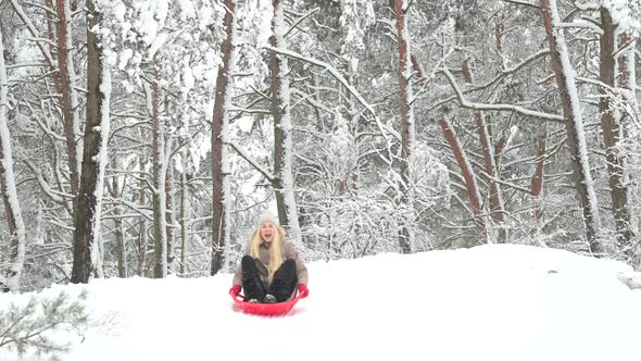 Young girl sledding from a slide in a beautiful snowy park
