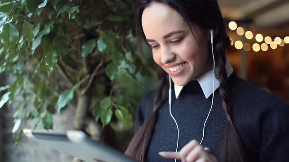 Young Girl Listening Music on Tablet alt