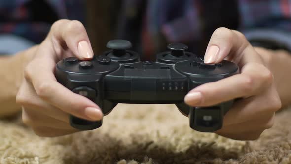 Teenager girl pressing joystick buttons in game competition, gadget addiction alt