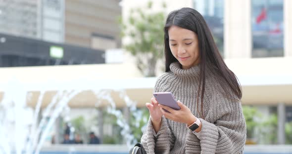 Woman working on mobile phone at outdoor alt