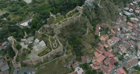Aerial dolly out shot of the Narikala fortress and the St. Nicholas church. alt