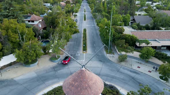 Aerial dolly in of Leonidas Montes windmill in roundabout with cars driving in avenue surrounded by alt