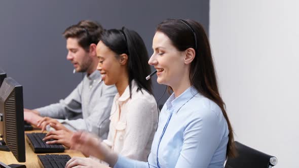 Smiling customer service executives talking on headset at desk 4k alt