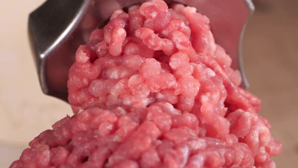 Filling Comes Out Through a Meat Grinder Sieve. Meat Grinder Close Up, Pile of Chopped Meat, Mincer alt