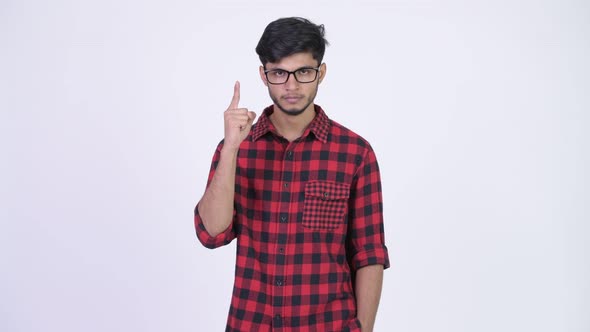 Young Handsome Bearded Indian Hipster Man Pointing Up alt
