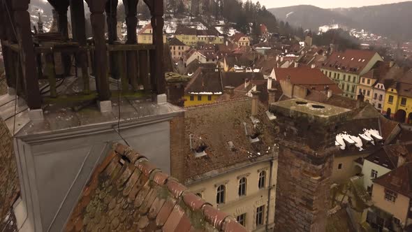 A dolly movement drone shot, capturing the rooftop of a vintage architechture in the city of Sighiso alt
