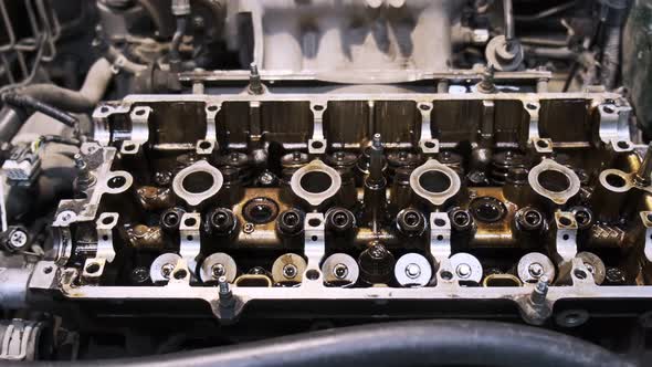 Disassembled car engine in oil. Cylinder head of an automobile engine. Refurbished car inside. Sixte alt