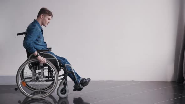 Adult Man in Wheelchair Looking at Camera Sitting at Home