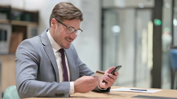 Businessman with Successful Online Payment on Smartphone in Office alt