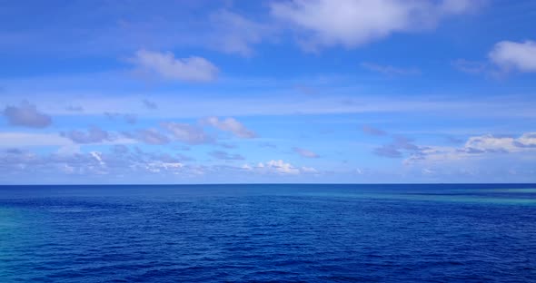 Wide angle overhead abstract shot of a white sandy paradise beach and aqua blue ocean background in  alt