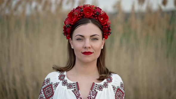Ukrainian Woman Walking in Embroidery Vyshivanka Dress on Reed Nature Background alt
