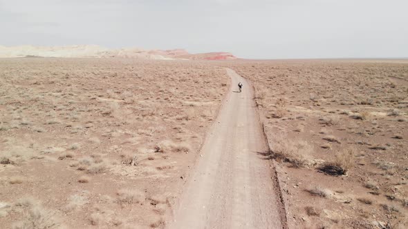 Drone Shot of Bicyclist Ride in Canyon Desert Mountains in Kazakhstan alt